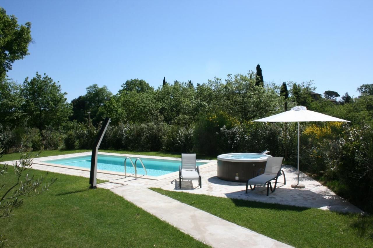 A backyard with a swimming pool, hot tub, and outdoor seating area.