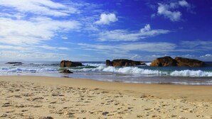A beach with large rocks, waves, and a clear sky. - Air Conditioning *  Secured Parking * BBQ * No Linen (South West Rocks)