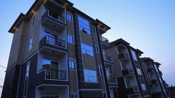 A multi-story residential building with balconies, large windows, and a modern architectural design. - Najjera, Kampala 1bed With Balcony, Wifi & Parking (Kampala)