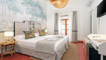 Una habitación de hotel con una cama grande, un escritorio, un televisor y una pared con un cuadro.