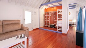 Una sala de estar moderna con piso de madera, un sofá y una mesa de centro blanca.