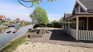 Ein Haus am Flussufer mit Anlegesteg, überdachter Terrasse und Flussblick.