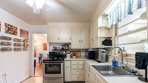 A modern kitchen with stainless steel appliances, white cabinetry, and a built-in microwave.