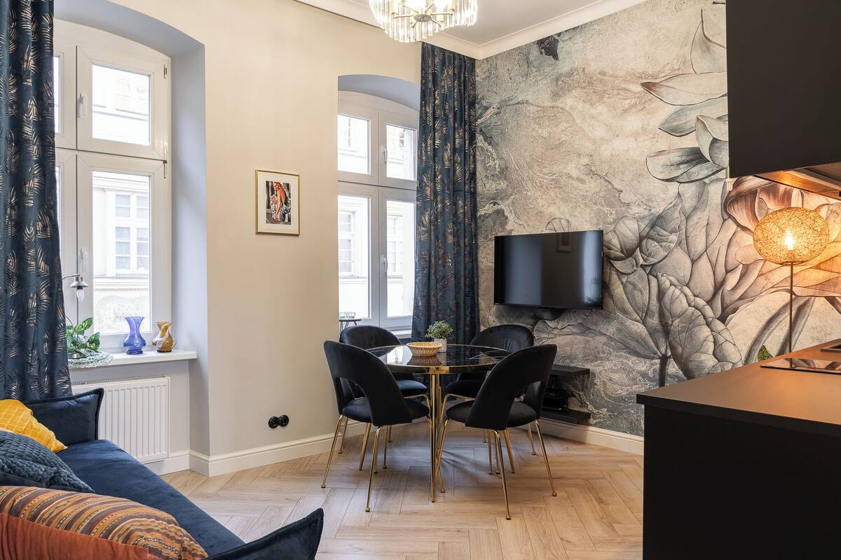 Una sala de estar moderna con comedor, ventanas amplias, un televisor de pantalla plana y una chimenea.