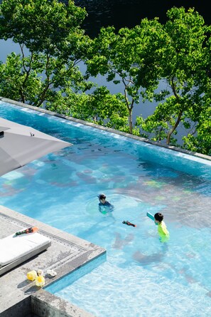 Alberca al aire libre, sombrillas en la alberca y camastros 