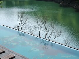 Una piscina al aire libre, sombrillas, sillones reclinables de piscina