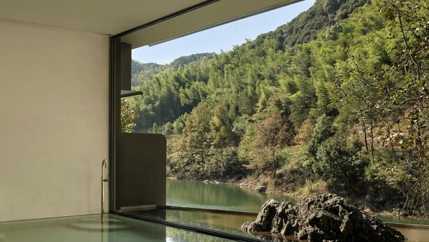 A modern interior with a glass floor leading to a river view, a minimalist table, and a large window. - Yakamoz qianchuan Hotel (Hangzhou)
