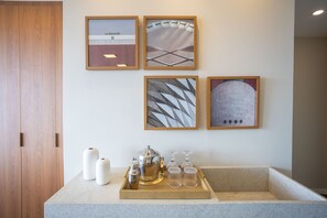 A hotel room with a wooden door, a marble countertop, and four framed artworks on the wall. - VN Millennium (São Paulo)