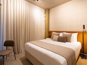 A hotel room with a large bed, a chair, a bedside table, and a lamp. - VN Millennium (São Paulo)