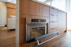 A modern kitchen with built-in appliances, including a stainless steel oven and a microwave. - VN Millennium (São Paulo)