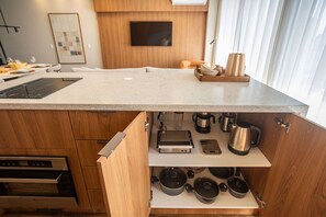 A modern kitchen with a large island, built-in appliances, and a variety of cookware. - VN Millennium (São Paulo)