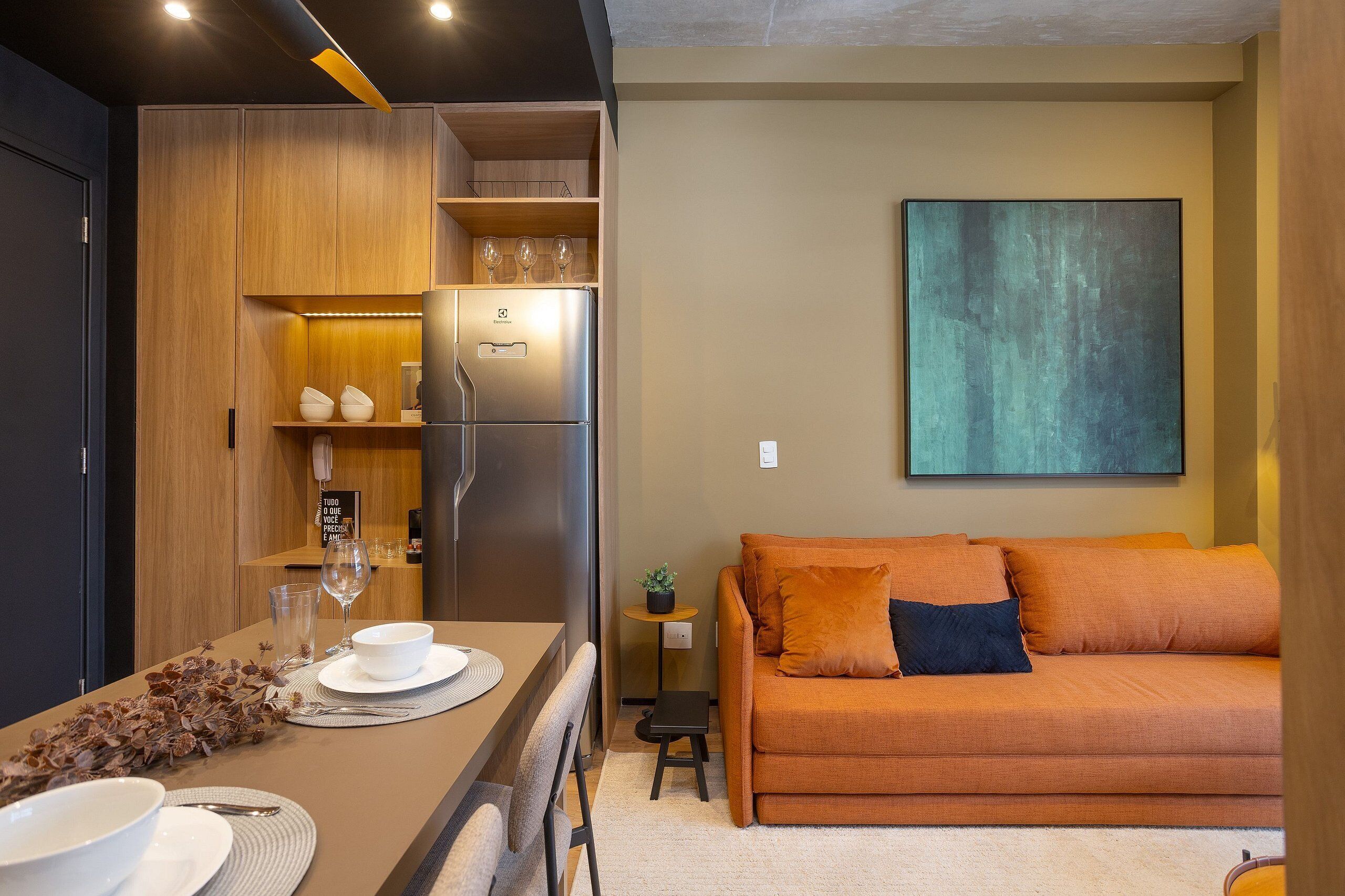Un espacio habitable compacto con kitchenette, comedor y sofá.