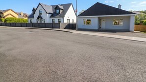 A residential street with houses, a clear sky, and a paved road.