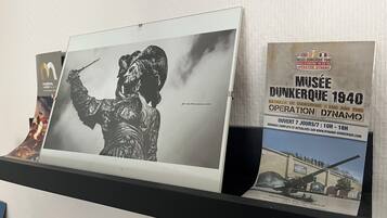 Une photographie en noir et blanc représentant un soldat, un livre intitulé « MUSÉE DUNKERQUE 1940 » et une brochure portant le même titre sont exposés.