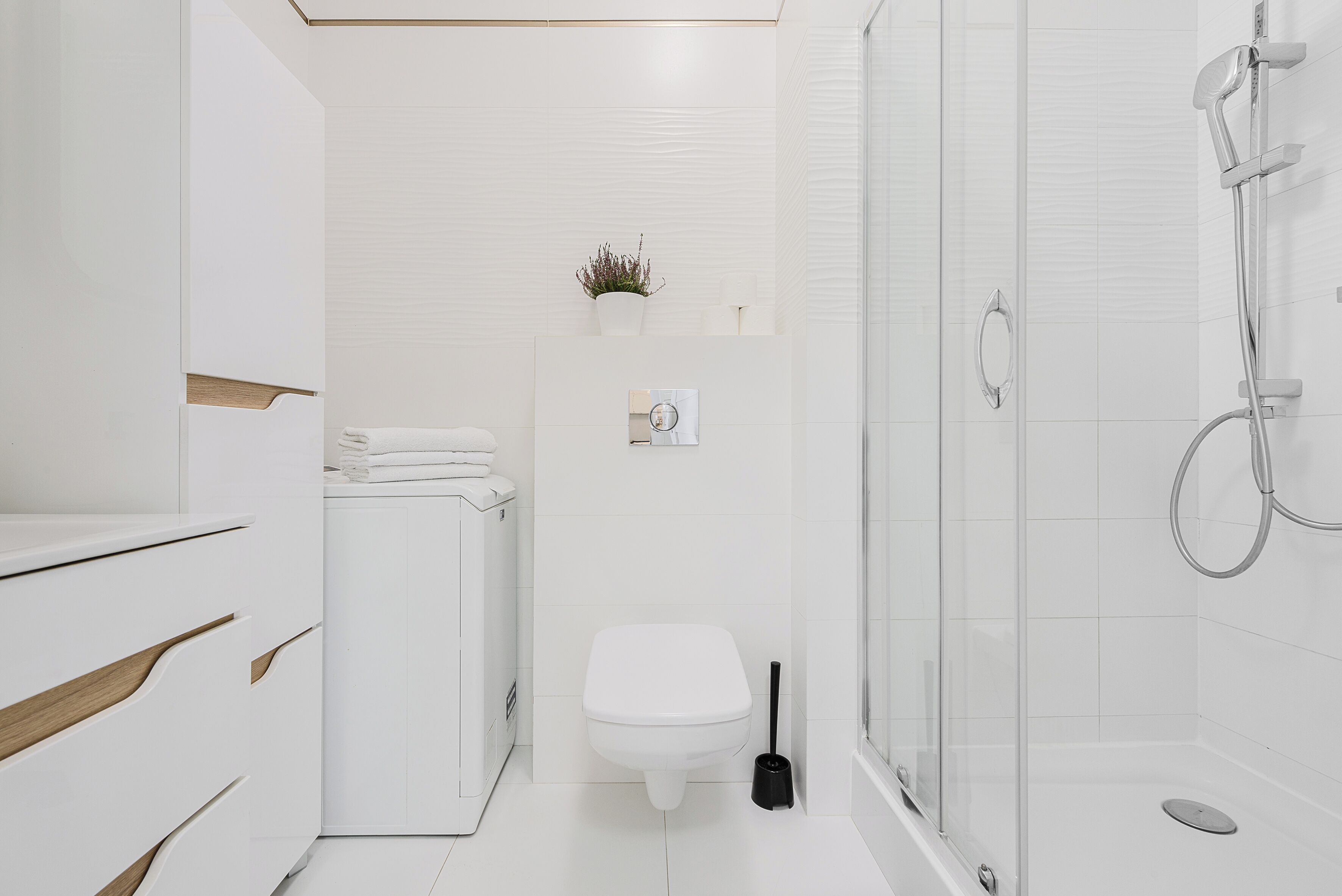 A modern bathroom with a toilet, bidet, and glass-enclosed shower.