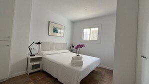A bedroom with a bed, a nightstand, a window, and a radiator. - Budha's apartment, relax & confort center Calafell (Calafell)
