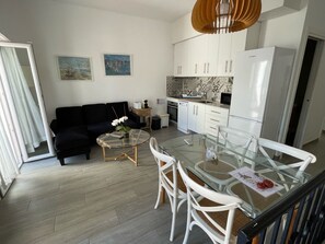 A modern kitchen with white cabinets, a built-in oven, and a microwave. - Budha's apartment, relax & confort center Calafell (Calafell)