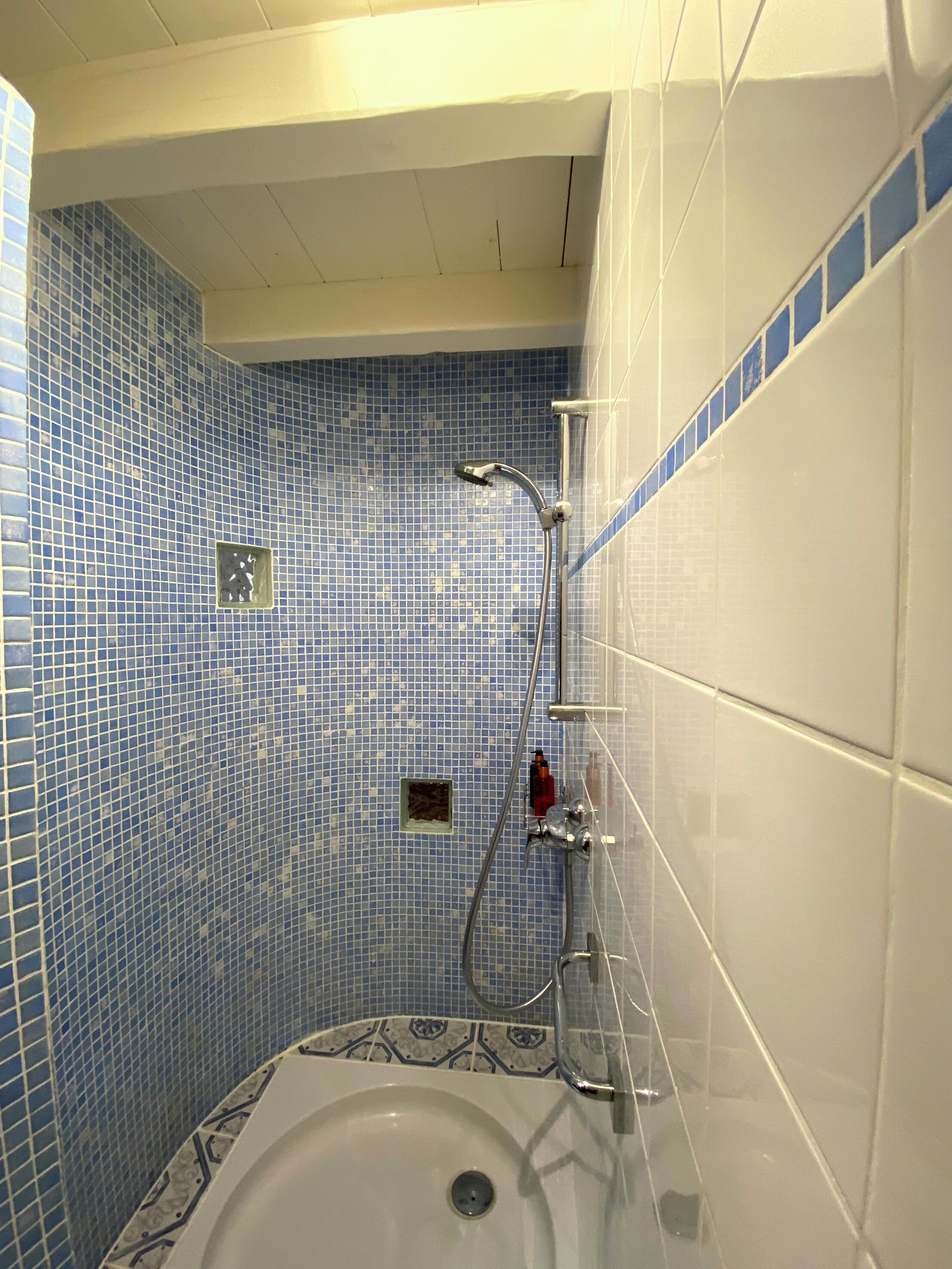 A bathroom with a bathtub, a shower, and a sink.