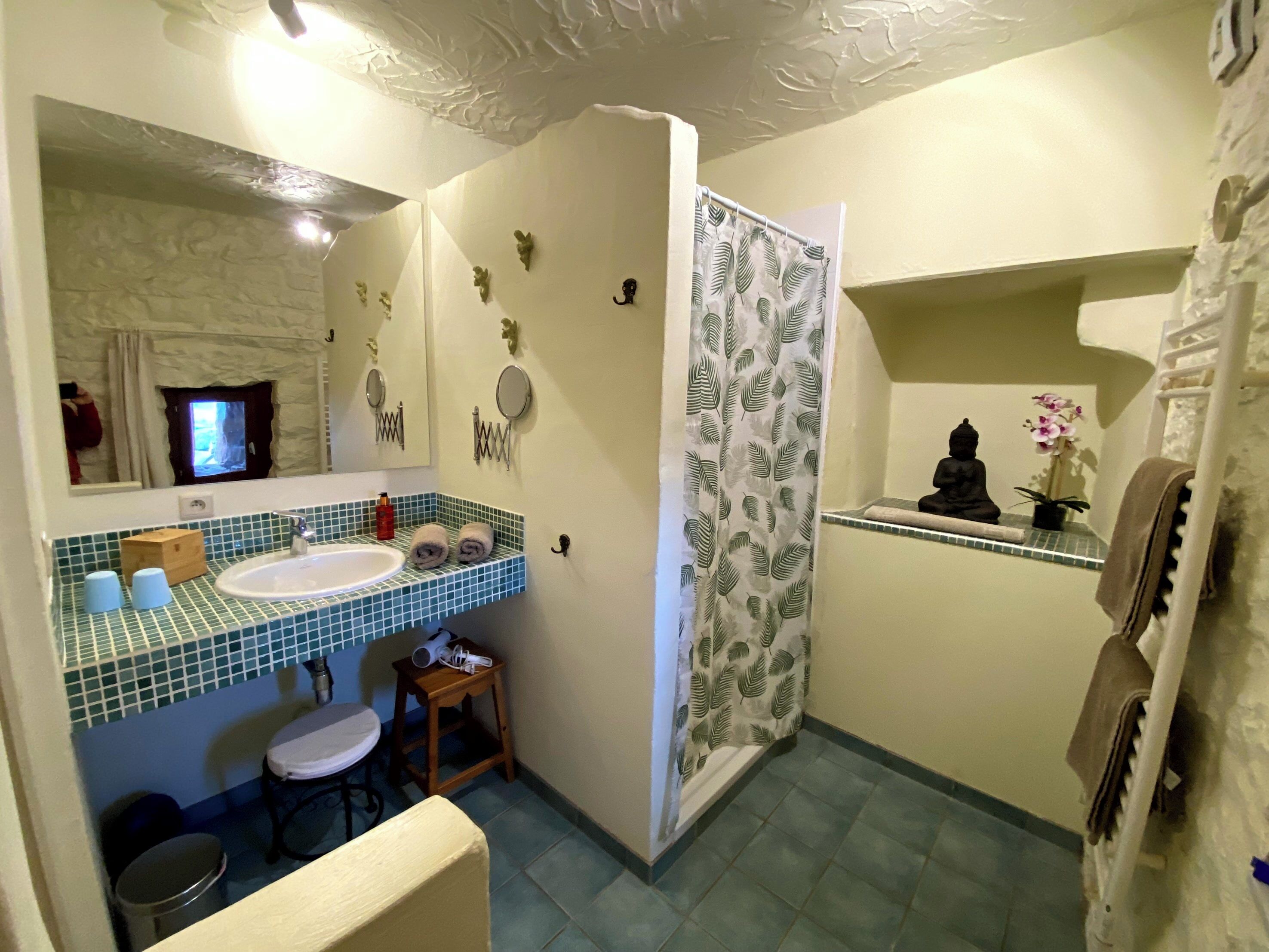 A bathroom with a sink, mirror, and shower curtain.