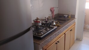 A kitchen with wooden cabinets, a white refrigerator, a gas stove, and a sink. - Nice apartment in marakech, for a good stay  (Marakech)