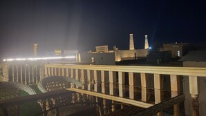 A night view of a bridge with a railing and a distant illuminated structure. - Ulli Oy Boutique Hotel & Terrace (Khiva)