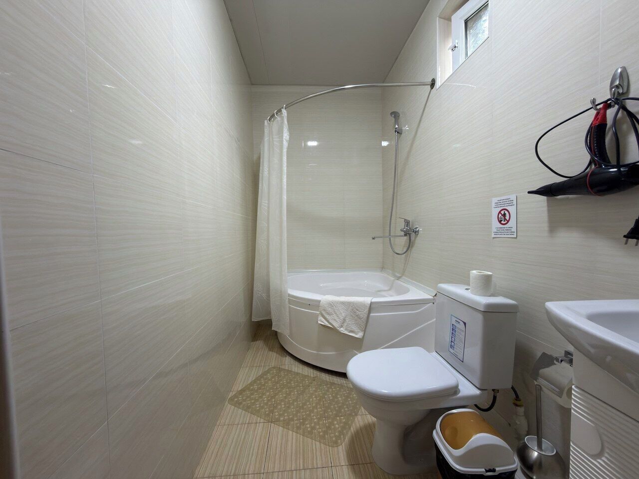 A small, clean bathroom with a shower, toilet, and sink.