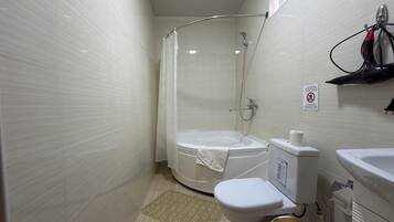 A small, clean bathroom with a shower, toilet, and sink.