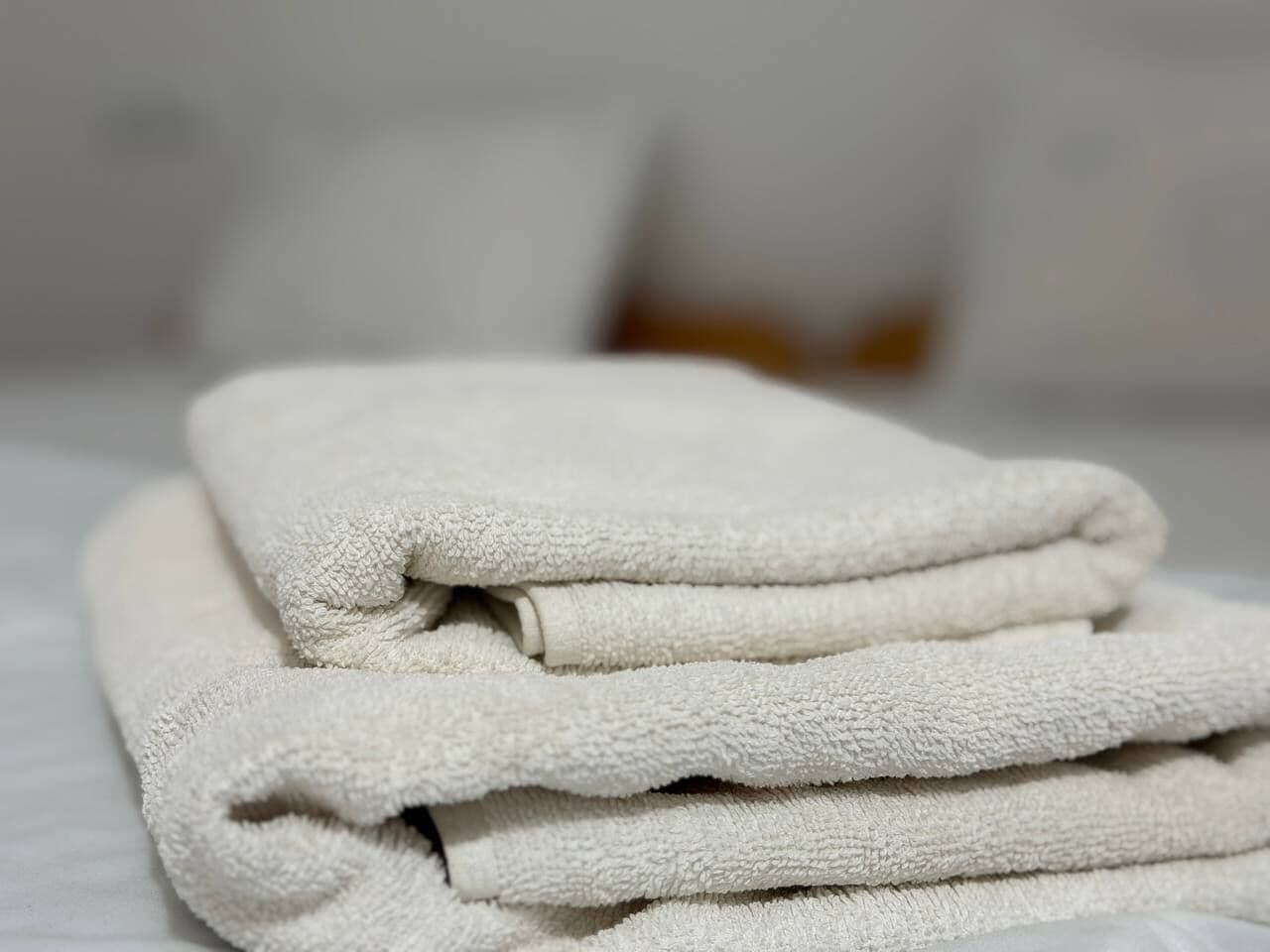 Un montón de toallas blancas sobre una cama.