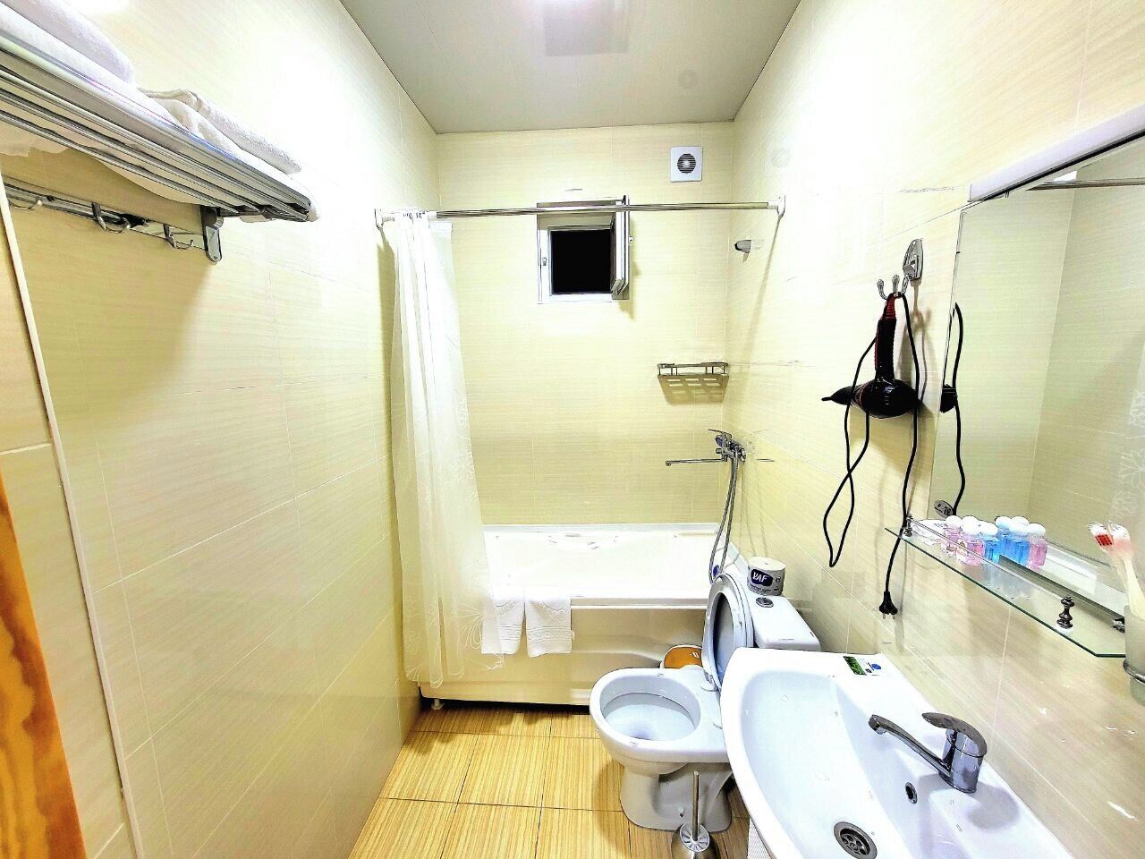 Une petite salle de bain comprenant des toilettes, un lavabo et une baignoire.