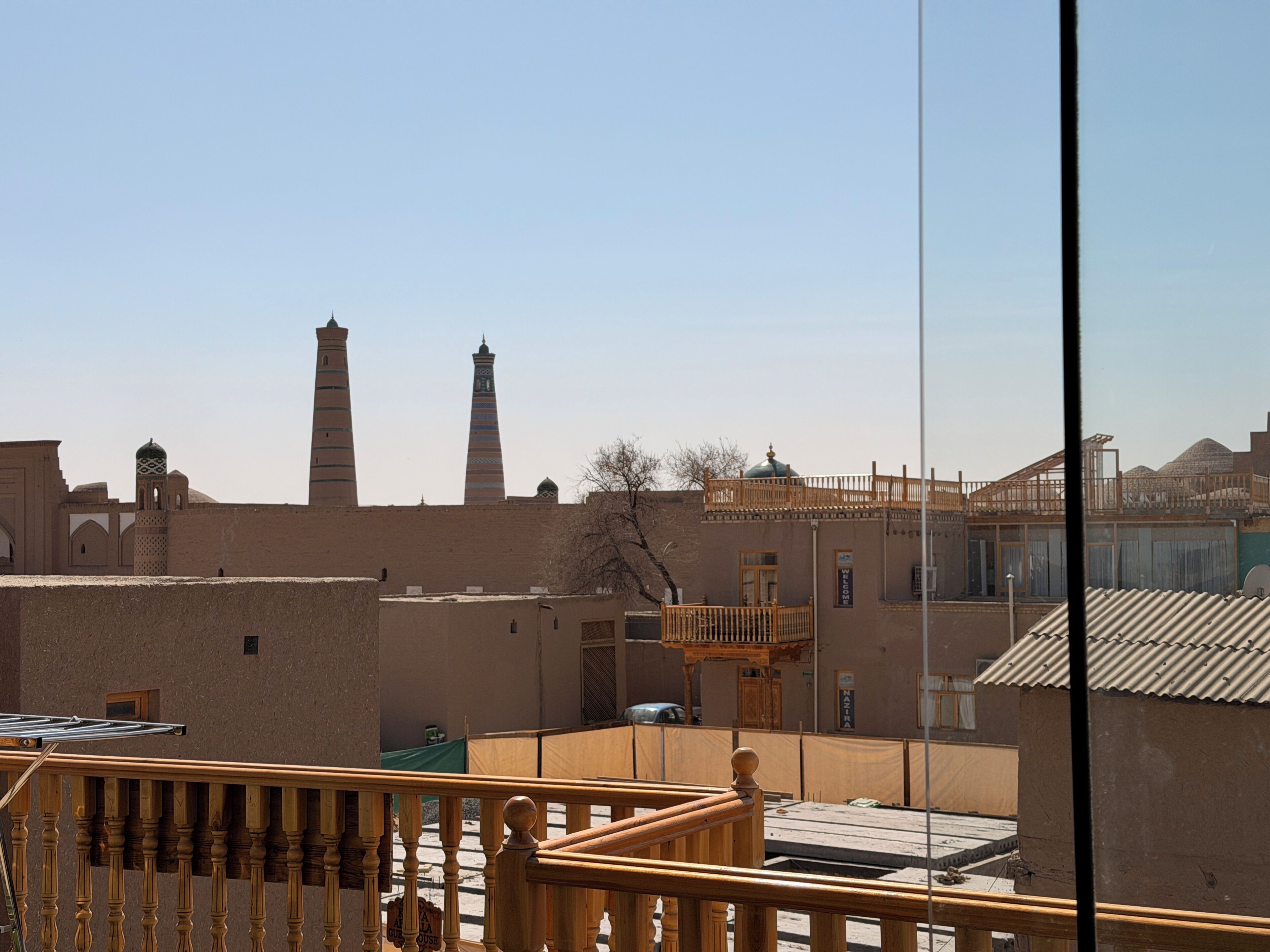 A view of a building with a balcony, a wooden fence, and a clear sky.