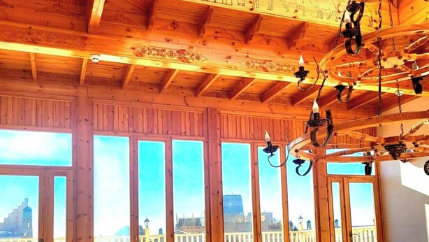 A wooden interior with large windows, a balcony, and a staircase. - Ulli Oy Boutique Hotel & Terrace (Khiva)