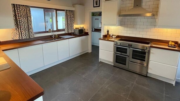 Una cucina moderna con mobili bianchi, forno integrato e microonde.