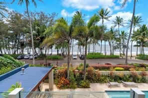Vista di un resort con piscina, palme e spiaggia.