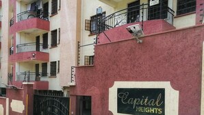 Un edificio residencial de varios pisos con balcones, una entrada con portón y un letrero que dice 'Capital Heights'.