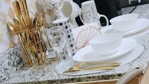Una cocina con estufa, ollas y diversos utensilios de cocina.