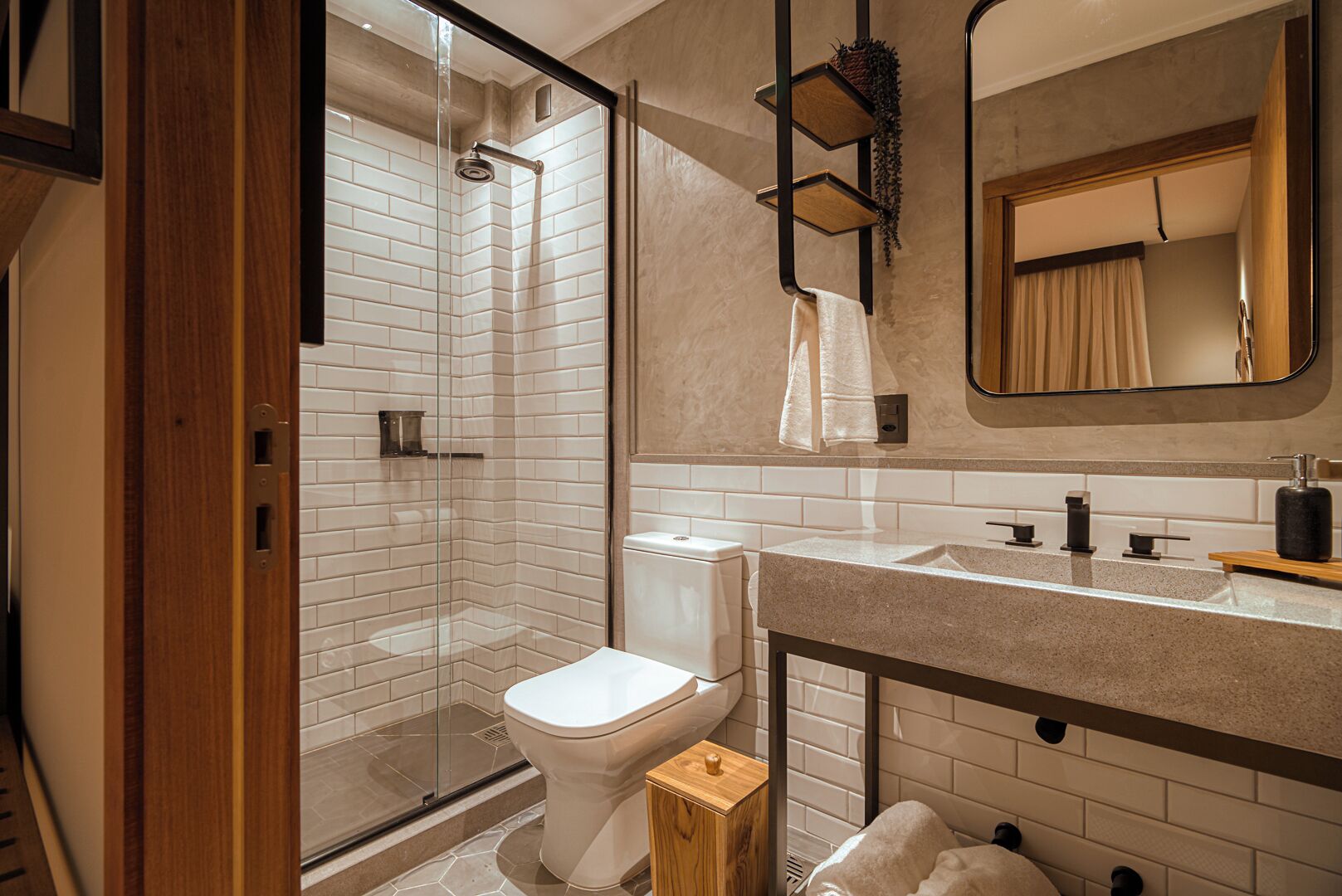 Une salle de bain moderne avec une douche à parois de verre, des toilettes blanches et un meuble-lavabo avec un miroir et un évier.