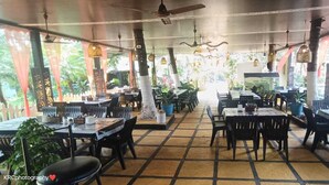 An indoor restaurant with multiple tables and chairs, ceiling fans, and hanging lights. - Dom Pedros Haven Resort - Tranquil Retreat by the Sea (Majorda)