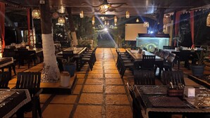An outdoor restaurant with multiple tables and chairs, a ceiling fan, and decorative lighting. - Dom Pedros Haven Resort - Tranquil Retreat by the Sea (Majorda)