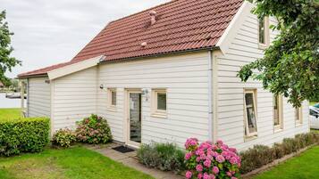 A single-story house with a red-tiled roof, white siding, and a small front porch.