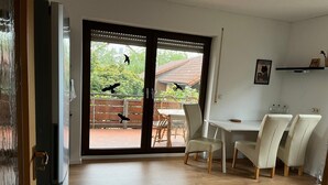 A modern kitchen with a wooden countertop and a dining area with white chairs. - Apartment in Hallstadt by Bamberg the world heritage City (Hallstadt)