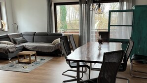 A modern living room with a dining table, chairs, a sofa, and a view of the outdoors. - Apartment in Hallstadt by Bamberg the world heritage City (Hallstadt)