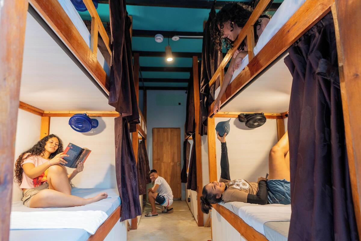 Un dormitorio con literas, un ventilador y una puerta.