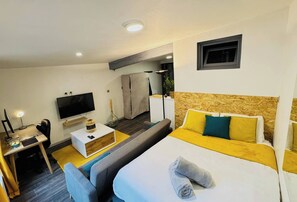 Relax in a spacious room with a large bed, flat-screen TV, and comfortable seating area.