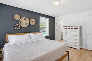 Une chambre à coucher avec un lit, une commode et des éléments de décoration murale.