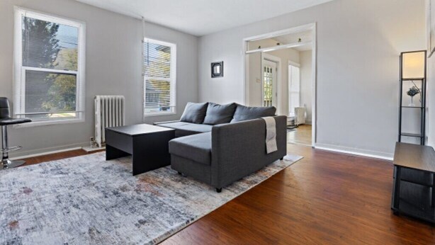 A modern living room with a grey sectional sofa, a small black coffee table, and a patterned rug. - Cozy and Convenient Family Getaway (DeKalb)