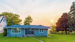 A single-story house with a front yard and a driveway. - Quiet/charming 2-bedroom Sunset-Lake view cottage lovely Seneca lake, wine trail (Geneva)