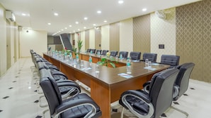 A conference room with a long table, chairs, and a staircase in the background. - Hotel Sky View - Zirakpur, Chandigarh (Dera Bassi)