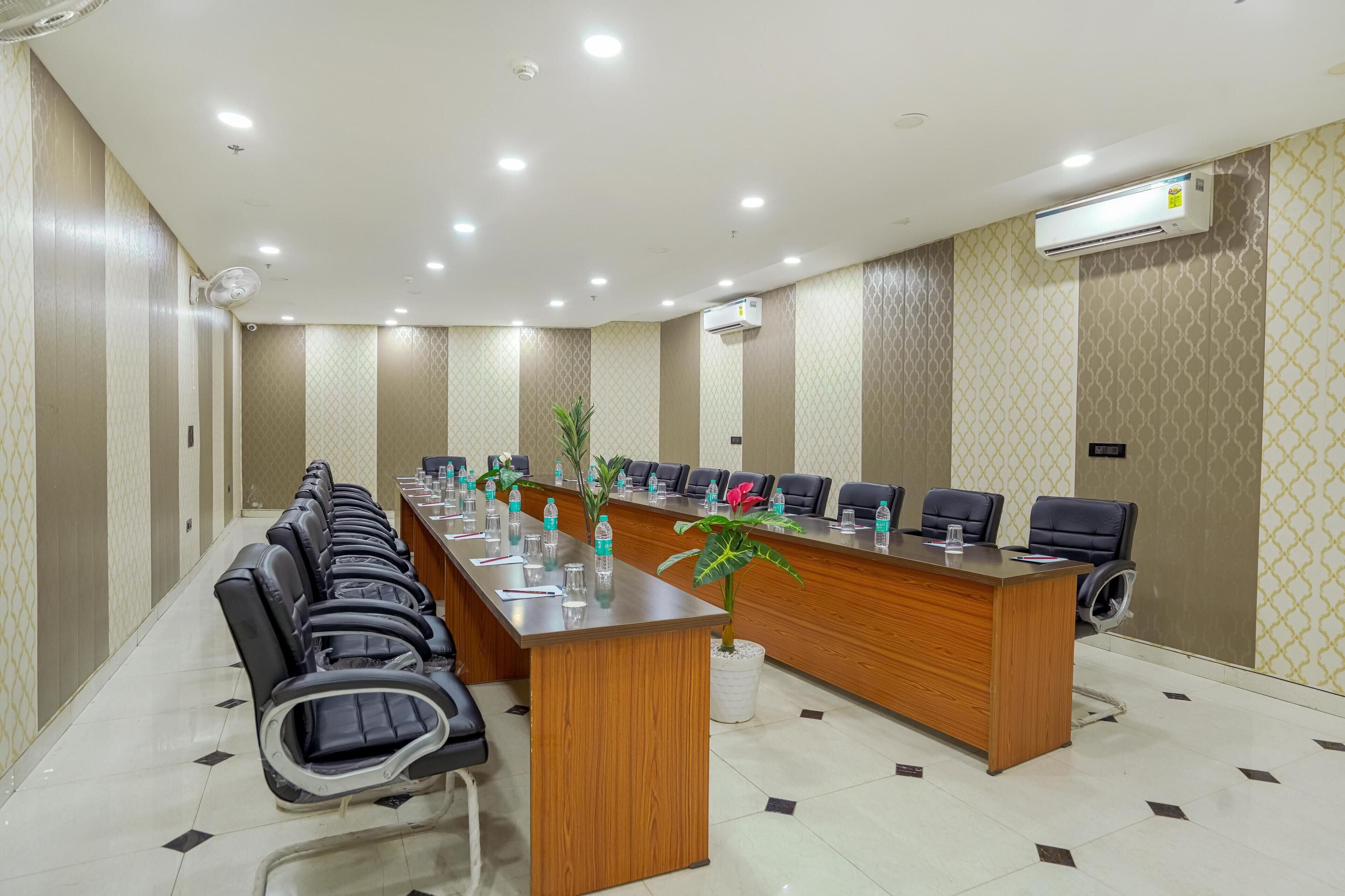 A conference room with a long table, chairs, and an air conditioning unit.