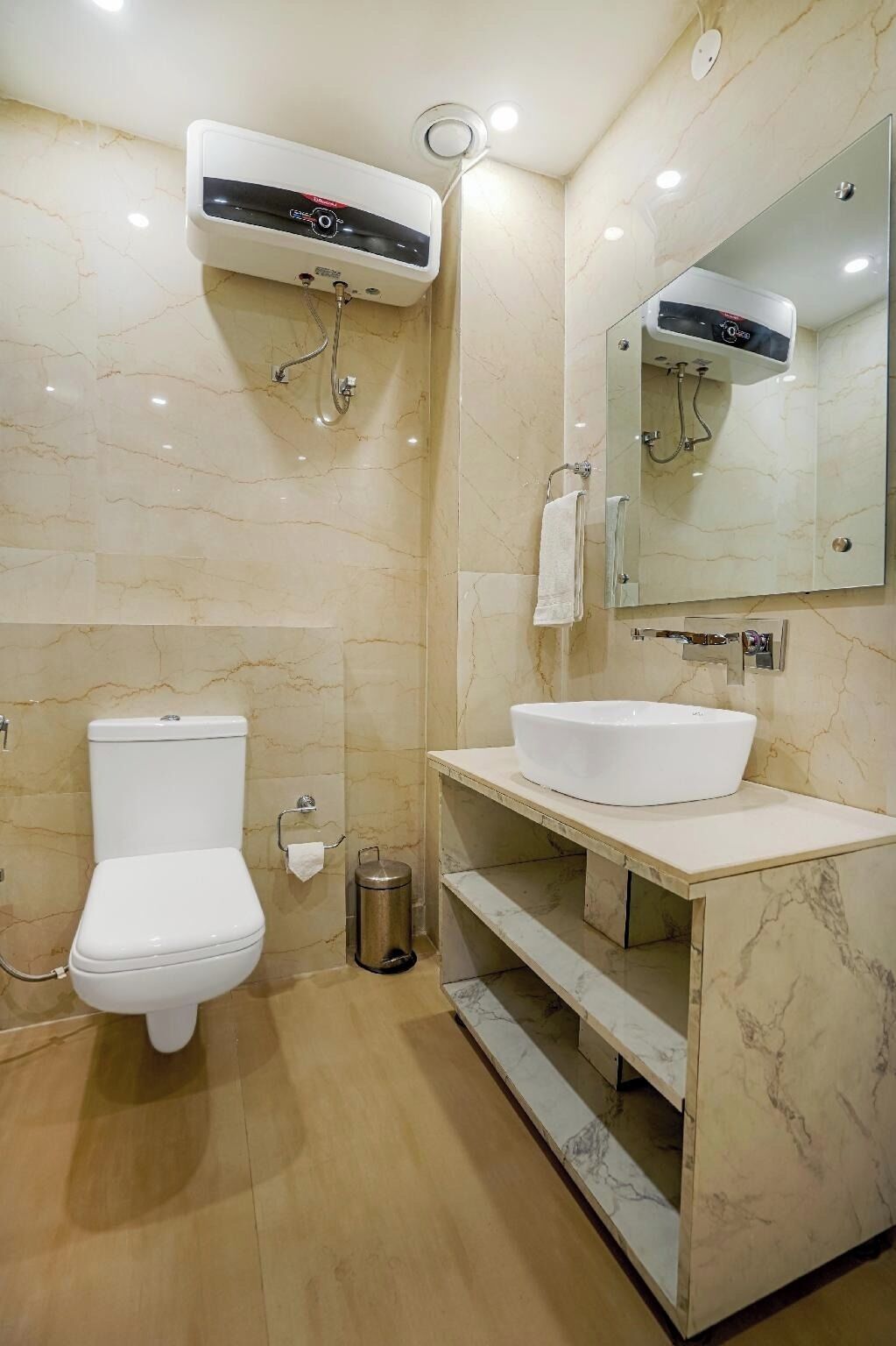 A bathroom with a toilet, a sink, a mirror, and a shower.