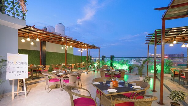 A rooftop restaurant with wicker furniture, a welcome sign, and a view of the cityscape. - Hotel Sky View - Zirakpur, Chandigarh (Dera Bassi)